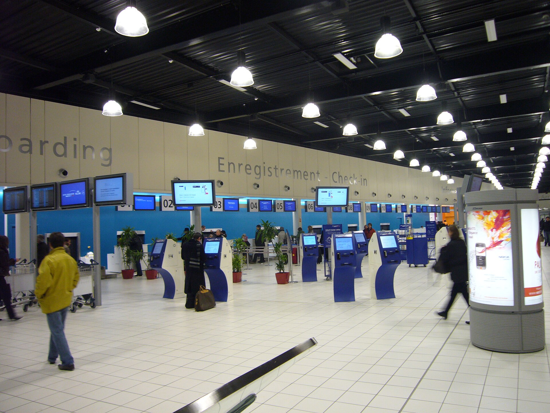 Hall d'arrivées du Terminal 2 de Roissy avec panneaux d'affichage des vols